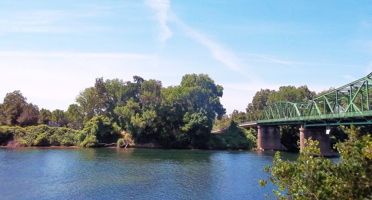 The American River and a green bridge near the confluence