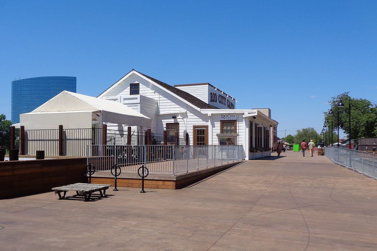 A white historic building beside the Old Sacramento boardwalk