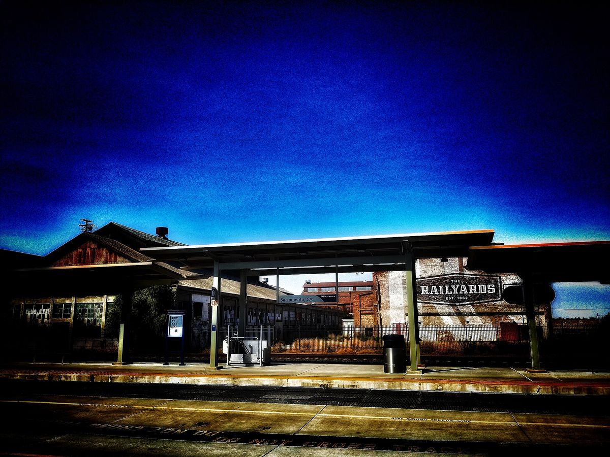 The Railyards sign above a platform shelter at dusk