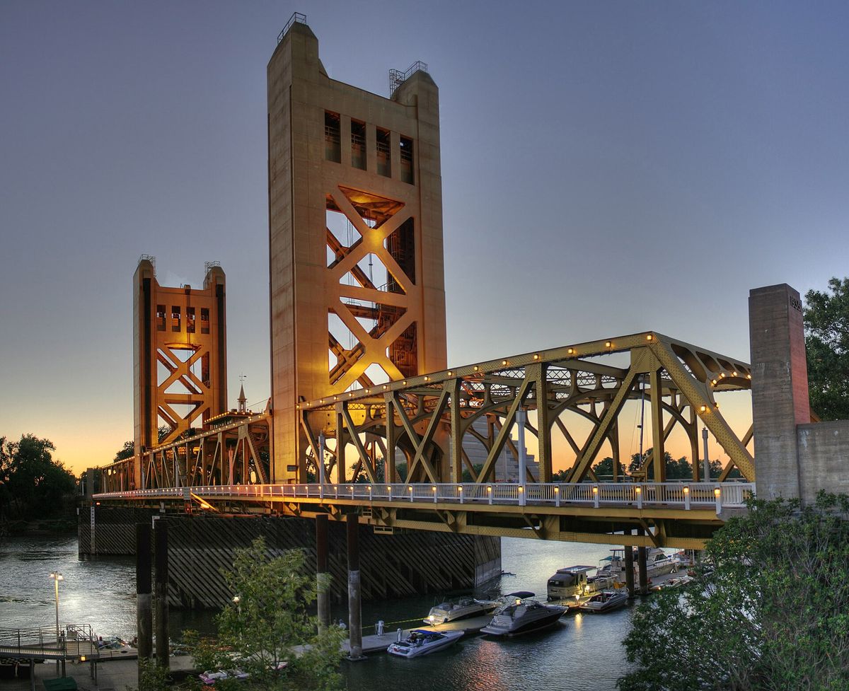 Tower Bridge at dusk, its towers lit gold over the river